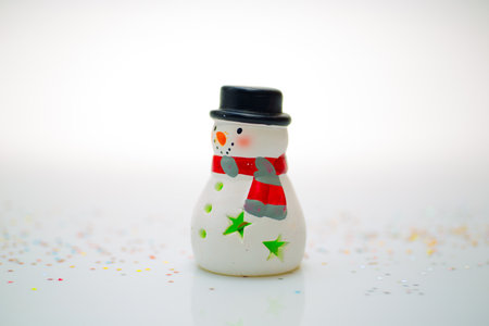 Christmas snowman on a white background with confetti and sparklesの写真素材