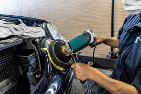 A mechanic polishes the headlights of a car.