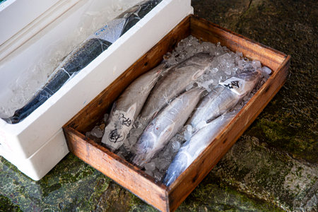 Fresh fish on ice in a wooden box at the fish market.の写真素材