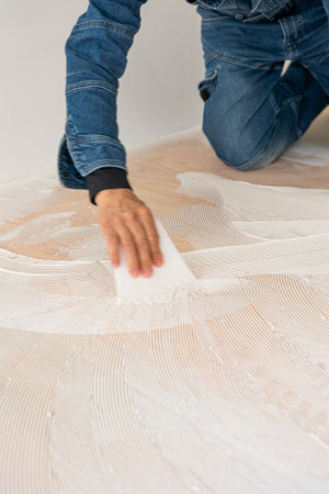 Close up of a man laying laminate flooring in a roomの写真素材