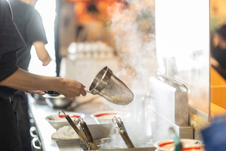 Professional chef in a restaurant kitchen preparing a meal. Selective focus.の写真素材