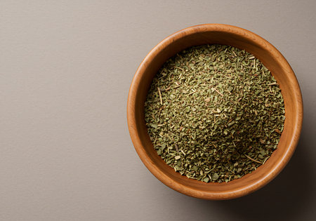 Dried tarragon herb in a bowl on grey background.の素材