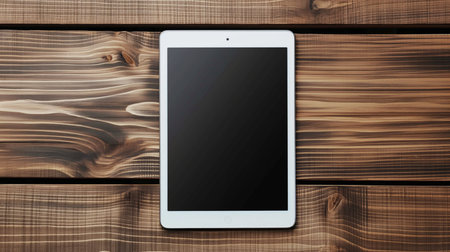 White tablet pc on wooden background. Top view with copy space.の素材