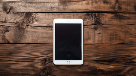 Tablet computer on wooden background. Top view with copy space.の素材