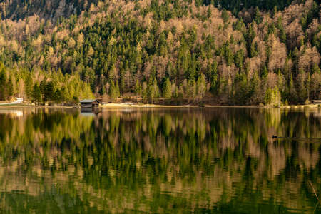 A alone hut with the great reflections of the Ferchensee and wood