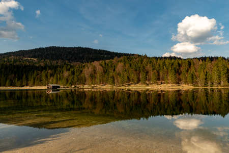 A alone hut in front of a forest with great reflections at Ferchensee