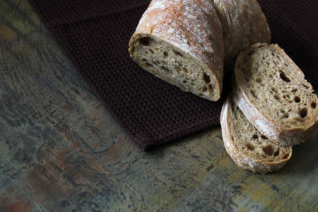 Ciabatta. Traditional Italian bread with two slices of bread placed on top of each other on the brown towel.の写真素材