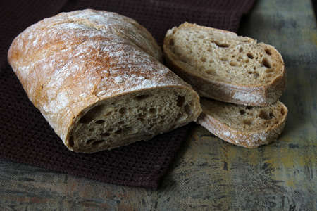 Ciabatta. Traditional Italian bread with two slices of bread placed on top of each other on the brown towel.の写真素材