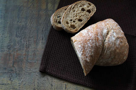 Ciabatta. Traditional Italian bread with two slices of bread placed on top of each other on the brown towel.の写真素材