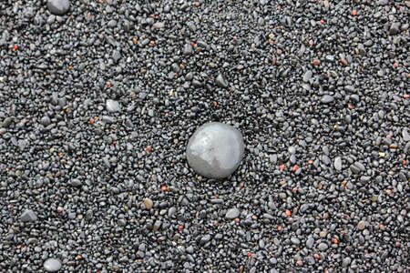 Gray round stone on a gray background.の写真素材