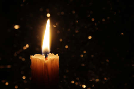 Candles Burning at Night. White Candles Burning in the Dark with focus on single candle in foreground.の写真素材