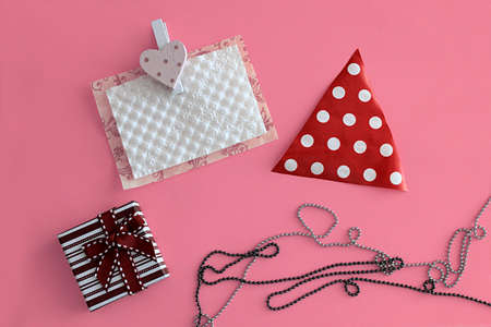 Items for the congratulations newborn baby on bright pink background. Dress, gift box, necklace and postcard. Text space.の写真素材
