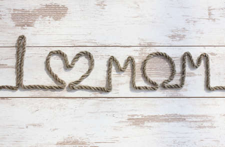 I love Mom. Composition on Mother's Day. Rope text on the wooden table, closeup.の写真素材