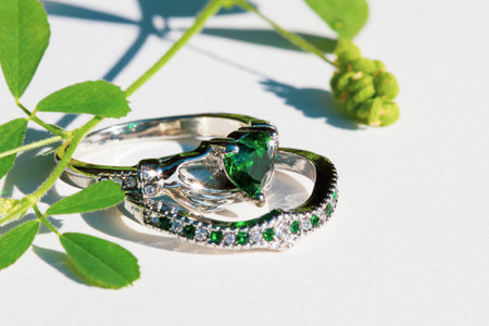 Claddagh ring with green emerald. Traditional Irish ring in shape of two hands holding a heart shaped green gemstone. Symbol of love, loyalty and friendship.の写真素材