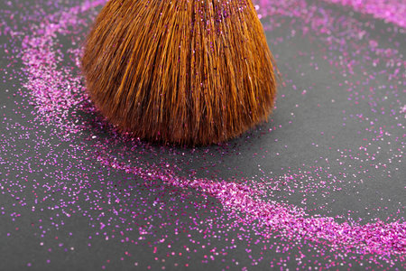 Colorful glitter crystals of eyelids makeup on black background. Beauty and fashion concept. Copy...