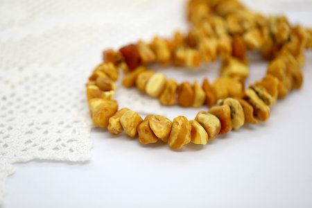 Amber necklace on white knitting napkin. Focus on the front. Close up.の写真素材