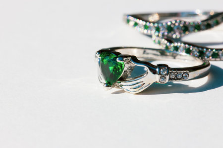 Claddagh ring with green emerald. Traditional Irish ring in shape of two hands holding a heart...