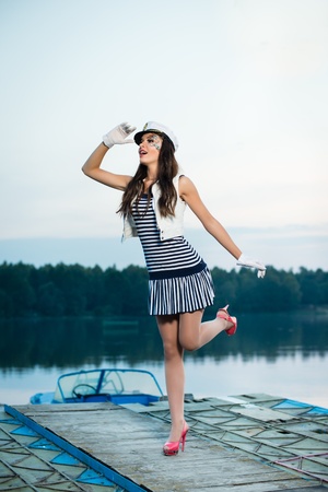 Young beautiful sailor woman on the boat at sunsetの写真素材