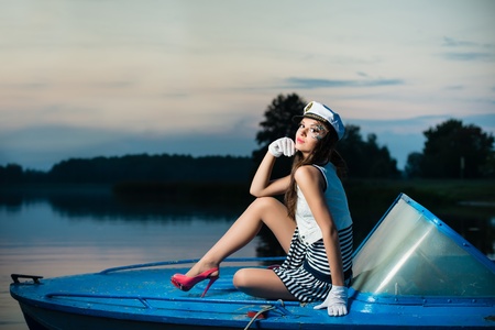 Young beautiful sailor woman on the boat at sunsetの写真素材