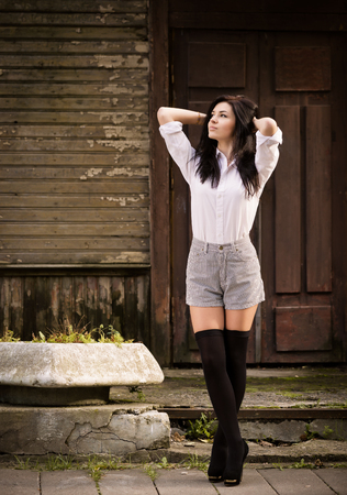 Fashion pretty young woman posing outdoor near a old wooden wall  Beautiful brunette with sensual lips の写真素材
