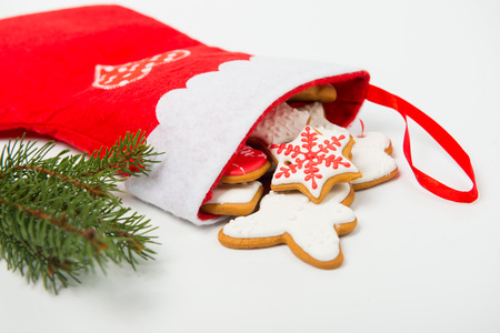 Christmas concept. Christmas sock with gingerbread and christmas tree branch on white backgroundの写真素材