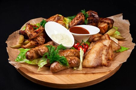 meat and snack set. pub, restaurant, bar food concept. meat appetizers set with grill chicken, sausages, tomatoes cherry, souses and fresh greens.の写真素材