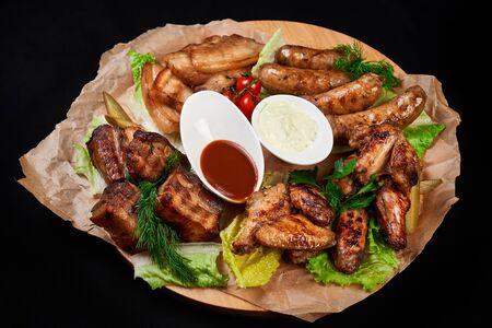 meat and snack set. pub, restaurant, bar food concept. meat appetizers set with grill chicken, sausages, tomatoes cherry, souses and fresh greens.の写真素材