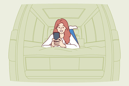 Woman tourist lies in campervan and uses phone smiling, enjoying opportunity to travelのイラスト素材