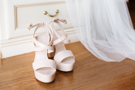 Bridal pink shoes standing in front of the nightstand. Bridal veil falling down from the nightstand.の写真素材