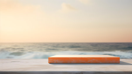 Square Stone Podium in orange Colors in front of a blurred Seascape. Luxury backdrop for product presentationの素材
