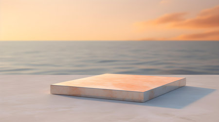 Square Marble Podium in light orange colors in front of a blurred seascape. Luxury backdrop for product presentationの素材