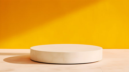 Round Stone Podium in front of a yellow Studio Background. White Pedestal for Product Presentationの素材