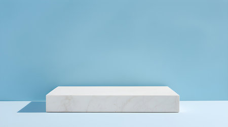 Square Stone Podium in front of a light blue Studio Background. White Pedestal for Product Presentationの素材