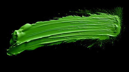 Isolated green brush stroke on a black background. Acrylic Paint Texture with Copy Spaceの素材