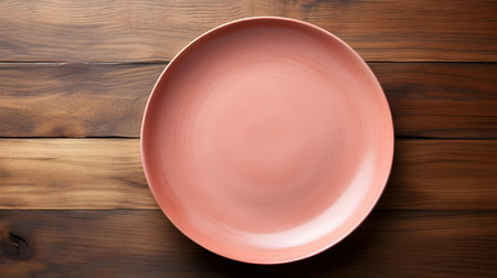 Top view of an empty plate in blush colors on a wooden table. Elegant template with copy spaceの素材
