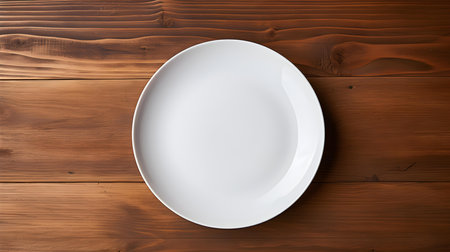 Top view of an empty plate in white colors on a wooden table. Elegant template with copy spaceの素材