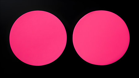 Two hot pink round paper notes on a black background. Brainstorming template with copy spaceの素材