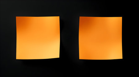 Two light orange square paper notes on a black background. Brainstorming template with copy spaceの素材