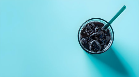 Black Summer Drink on a blue Background with Sunlight and Shadowsの素材