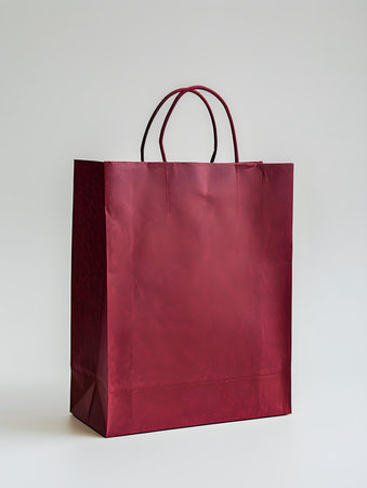 Dark red shopping bag on a white backgroundの素材