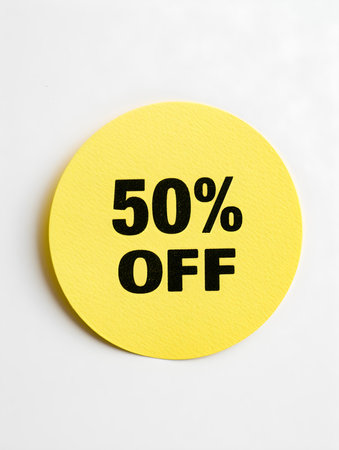 Black '50% OFF' Text on a Yellow Round Paper Note. White Backgroundの素材