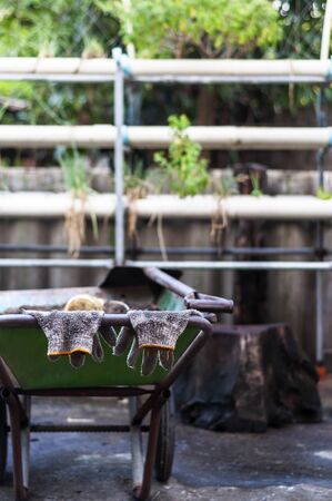 Worker gloves hanging on a cart handle after a hard work.の写真素材