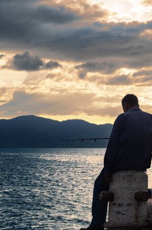 Man Fishing on The Harborの写真素材