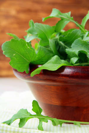 wooden cup with a green fresh arugula on the tableの写真素材
