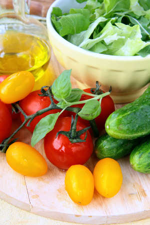 ingredients for the salad, cucumbers, tomatoes, olive oil and green salad mixの写真素材