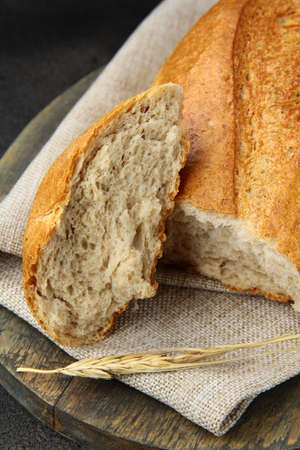 Loaf of white bread on a wooden kitchen board