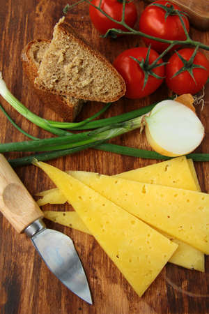 still life in a rustic style, cheese tomatoes and bread on a wooden backgroundの写真素材
