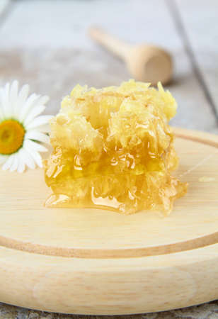 honeycomb on a wooden stand on the tableの写真素材