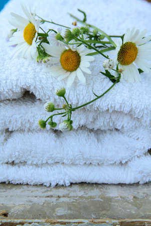 white towel with daisies on a wooden tableの写真素材