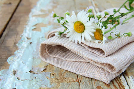 bouquet of daisies on the linen bag  on a wooden table rustic still lifeの写真素材